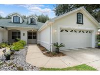Exterior view of a single story house with a two car garage and landscaped walkway at 1117 Athlone Way, Ormond Beach, FL 32174