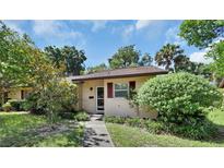 House exterior featuring a walkway, lush landscaping, and a charming entrance at 13 Villa Villar # 0, Deland, FL 32724