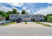 Three-unit townhome building with two-car garages and a shared driveway at 1610 Primo Ct, Holly Hill, FL 32117