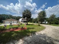 Home with detached garage and a charming front yard landscape at 3660 Grand Ave, Deland, FL 32720