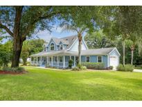 Two-story light blue house with a large front porch and yard at 1781 Windham Ct, Deland, FL 32720