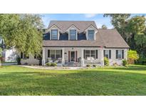 Two-story house with white exterior, front porch, and landscaping at 10 Hickory Ln, Flagler Beach, FL 32136