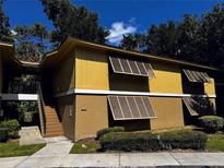 Exterior view of a two-story building with stairs and shutters at 110 Cypress Woods Ct # 7D, Deltona, FL 32725