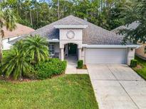 Single story home with two-car garage and lush landscaping at 1429 Areca Palm Dr, Port Orange, FL 32128