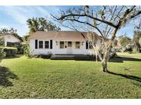 White house with brown roof, front porch, and lawn at 522 E Minnesota Ave, Deland, FL 32724