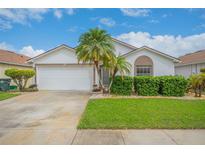 One-story home with a two car garage, lush lawn, and landscaping at 316 Dahoon Holly Dr, Daytona Beach, FL 32117