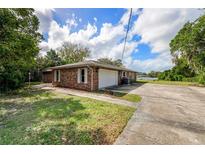 Brick house exterior showcasing a garage and walkway, offering curb appeal at 660 Saxon Blvd, Deltona, FL 32725