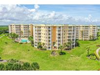 Aerial view of condo building with pool and lush landscaping at 4650 Links Village Dr # C303, Ponce Inlet, FL 32127