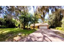 Single story house with driveway and mature trees at 1899 S Lehigh Dr, Deltona, FL 32738