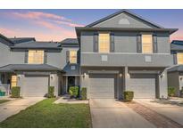 Two-story townhome with gray siding and two-car garage at 450 Tradition Ln, Winter Springs, FL 32708