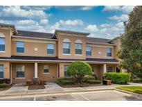 Tan townhouses with covered porches and landscaping at 384 Carina Cir, Sanford, FL 32773
