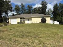 Single-story home with attached garage and green lawn at 1871 12Th St, Orange City, FL 32763