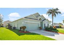 Two-story house with a green exterior, two-car garage, and well-manicured lawn at 101 Marathon Ln, Sanford, FL 32771