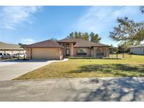 Brick house with a two-car garage and a well-maintained lawn at 1185 N Old Mill Dr, Deltona, FL 32725