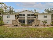 Two-story condo building with stairs and screened porches at 1600 Big Tree Rd # D6, South Daytona, FL 32119