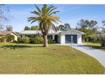 Ranch-style home with a well-manicured lawn and palm tree at 1437 Colin Kelly Ave, Daytona Beach, FL 32124