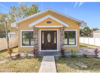Newly constructed yellow house with a brown door and walkway at 1604 Carmen Ave, Daytona Beach, FL 32117