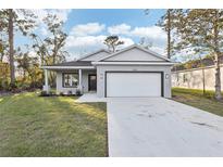 Newly constructed home with a gray exterior, two-car garage, and well-manicured lawn at 1690 East Pkwy, Deland, FL 32724