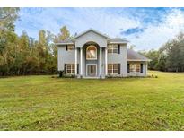 Two-story house with gray siding, large windows, and a spacious lawn at 1907 Enterprise Osteen Rd, Deltona, FL 32738