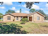 Brick ranch home with landscaped yard and driveway at 2332 Salem Dr, Deltona, FL 32738