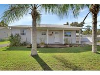 Charming single story home with metal roof, front porch, and well-manicured lawn at 24514 Snail Rd, Astor, FL 32102