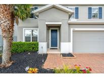 Front entrance with blue door and brick walkway at 3404 Grassy Lake View Ave, Minneola, FL 34715