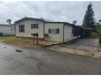 Single-wide mobile home with green trim and a screened porch at 1632 Bream Dr, Seville, FL 32190