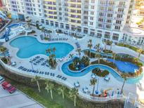 Expansive pool area with a lazy river, lounge chairs, and a waterslide at 300 N Atlantic Ave # 1803, Daytona Beach, FL 32118