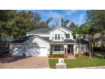 Two-story house with a three-car garage, stone accents, and a manicured lawn at 973 Bearded Oaks Ter, Longwood, FL 32779