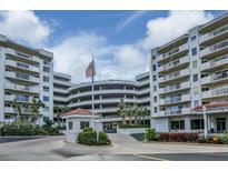 Exterior view of a condo building with parking and landscaping at 3 Oceans West Blvd # 4A5, Daytona Beach Shores, FL 32118