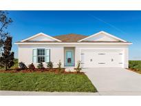 Single-story home with white exterior, teal door, and two-car garage at 1235 Tank Trl, Haines City, FL 33844