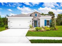 Single-story home with gray siding, stone accents, and a two-car garage at 1641 Laia Rd, Haines City, FL 33844
