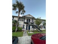 Two-story apartment building with a palm tree and stairs at 3651 N Goldenrod E Rd # 102, Winter Park, FL 32792