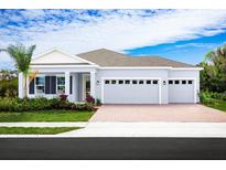 Single-story home with two-car garage, attractive landscaping, and a brick driveway at 2193 Aibonito Cir, Clermont, FL 34711