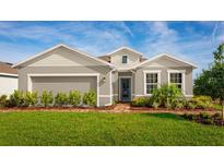 Single-story home with gray siding, landscaping, and a brick walkway at 10937 Sw 73Rd Ct, Ocala, FL 34476