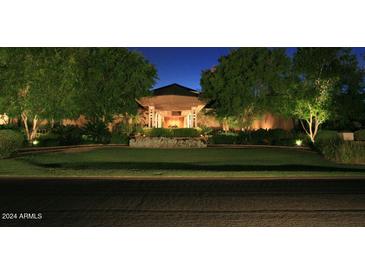 Elegant home exterior with manicured lawn and nighttime lighting at 15 Biltmore Estates Dr, Phoenix, AZ 85016