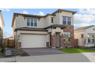 Two-story home with stone accents and a three-car garage at 22795 E Stacey Rd, Queen Creek, AZ 85142