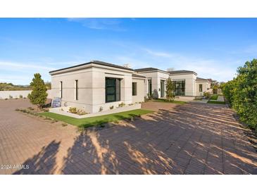 Stunning modern home with clean lines and a spacious paved driveway at 6512 E Hummingbird Ln, Paradise Valley, AZ 85253