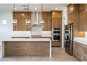 Modern kitchen with island and stainless steel appliances at 7566 W Gelding Dr, Peoria, AZ 85381