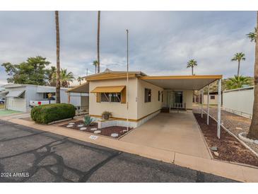 Mobile home exterior with carport and landscaping at 8421 E Main St # 106, Mesa, AZ 85207