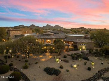 Luxury estate at sunset with mountain views; expansive grounds and pool at 10629 E Troon North Dr, Scottsdale, AZ 85262