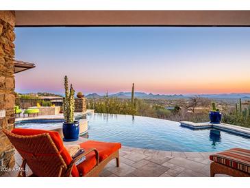 Relaxing patio with infinity pool, spa, and sunset views at 11070 E Rolling Rock Dr, Scottsdale, AZ 85262