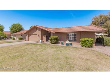 Single-story home with attached garage and well-maintained lawn at 427 Leisure World --, Mesa, AZ 85206