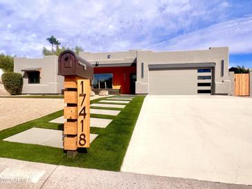 Modern home with a gray stucco exterior, attached garage, and landscaped yard at 17418 E La Pasada Dr, Fountain Hills, AZ 85268