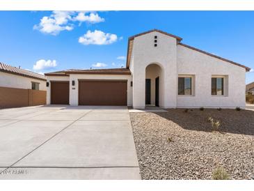 Modern stucco home with a three-car garage and desert landscaping at 37645 W Padilla St, Maricopa, AZ 85138