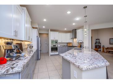 Modern kitchen with granite countertops and stainless steel appliances at 16290 W Mission Cove Ln, Surprise, AZ 85374