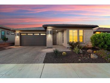 Single-story home with a gray garage door, light-colored stone, and desert landscaping at 13330 W Milton Dr, Peoria, AZ 85383