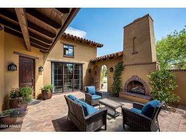 Inviting patio with fireplace and seating area, perfect for outdoor relaxation at 38749 N 104Th Way, Scottsdale, AZ 85262