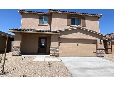 Two-story house with beige exterior and stone accents at 24668 W Alta Vista Rd, Buckeye, AZ 85326