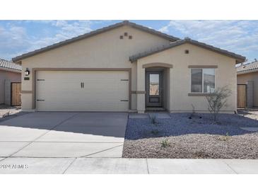 One-story house with a beige exterior, a two-car garage, and a gravel landscaping at 24636 W St Catherine Ave, Buckeye, AZ 85326